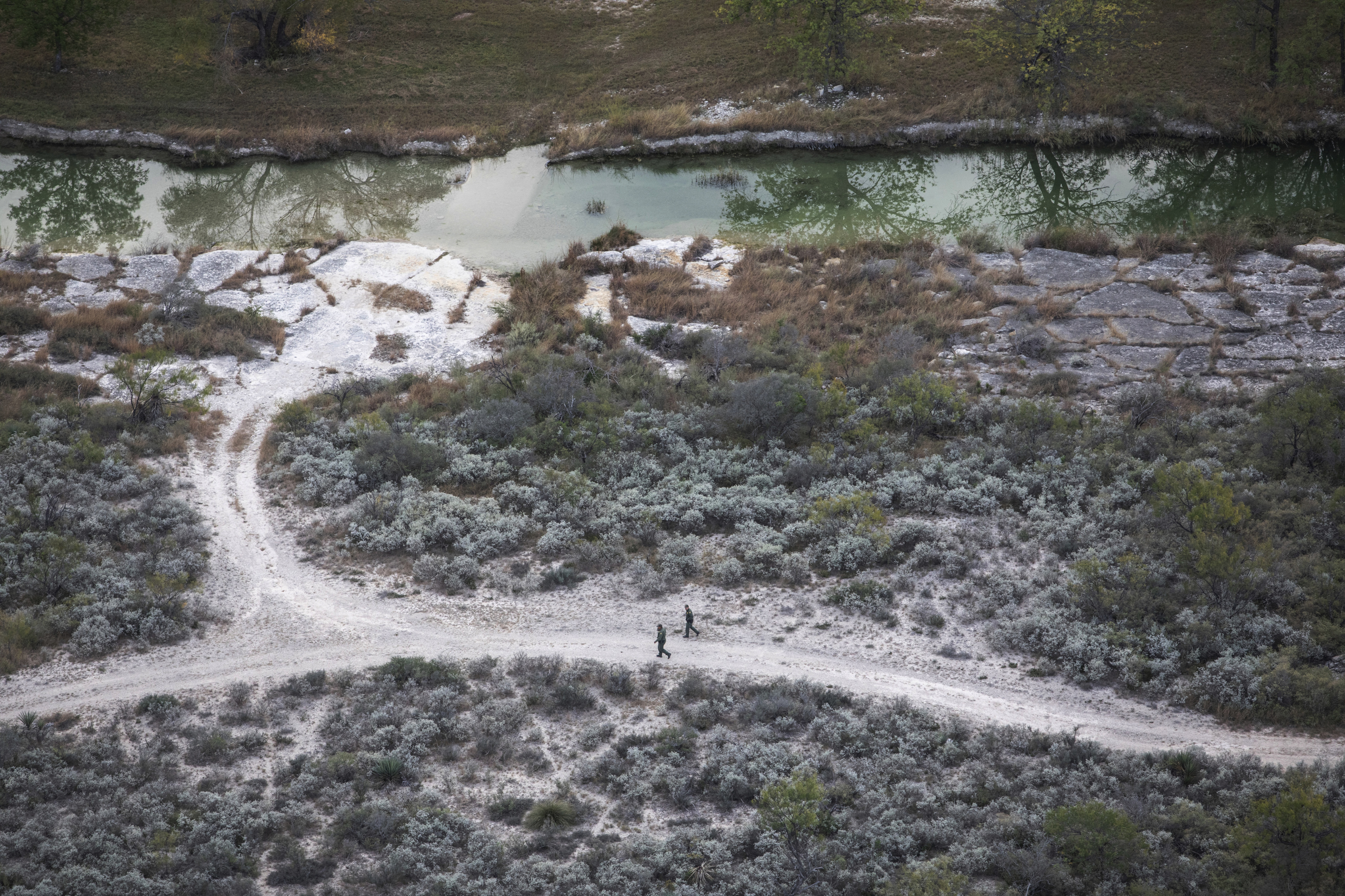 Una foto aérea de agentes de la Patrulla Fronteriza buscando a los migrantes que intentan cruzar a Estados Unidos en un rancho en el condado de Kinney, Texas, el 19 de noviembre de 2021. (Kirsten Luce/The New York Times)