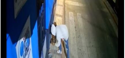 Momento en que un hombres se roba la comida para perros callejeros en Amatitlán. (foto: captura/La Doña News/Facebook)