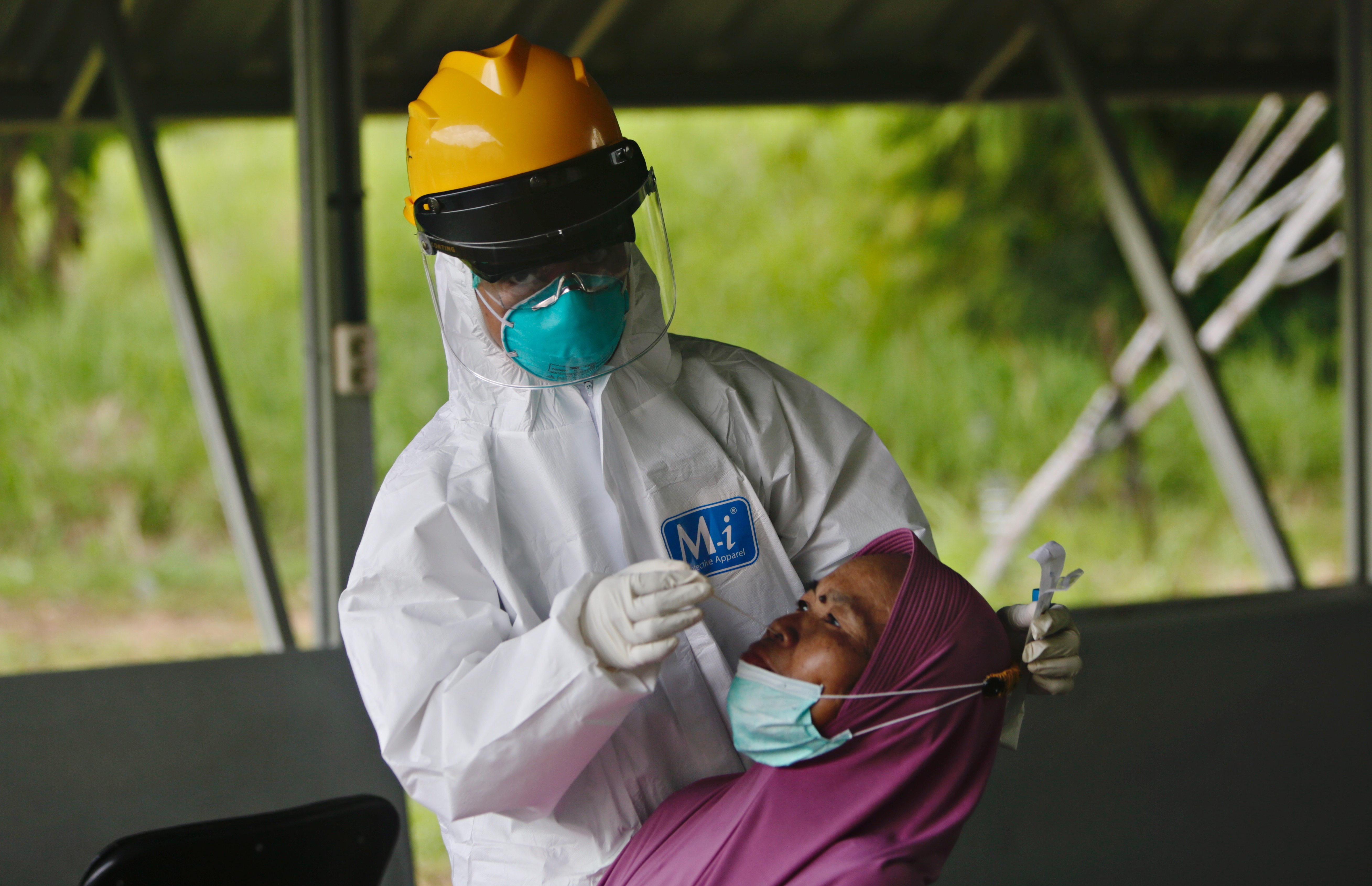 Tangerang (Indonesia), 03/02/2022.- A Health worker in hazmat suit collects specimen samples from a woman in isolation due to being exposed to COVID-19 with the Omicron variant, at The House Against COVID-19 in Tangerang, Indonesia, 03 February 2022. The wave of the Omicron variant hit a number of countries, including Indonesia. The Indonesian government has recorded a significant increase in cases in recent times, and it is estimated that the peak of the Omicron wave in Indonesia will occur at the end of February. The peak of the new variant storm is even predicted to be two to three times larger than the peak of the Delta variant wave EFE/EPA/ADI WEDA