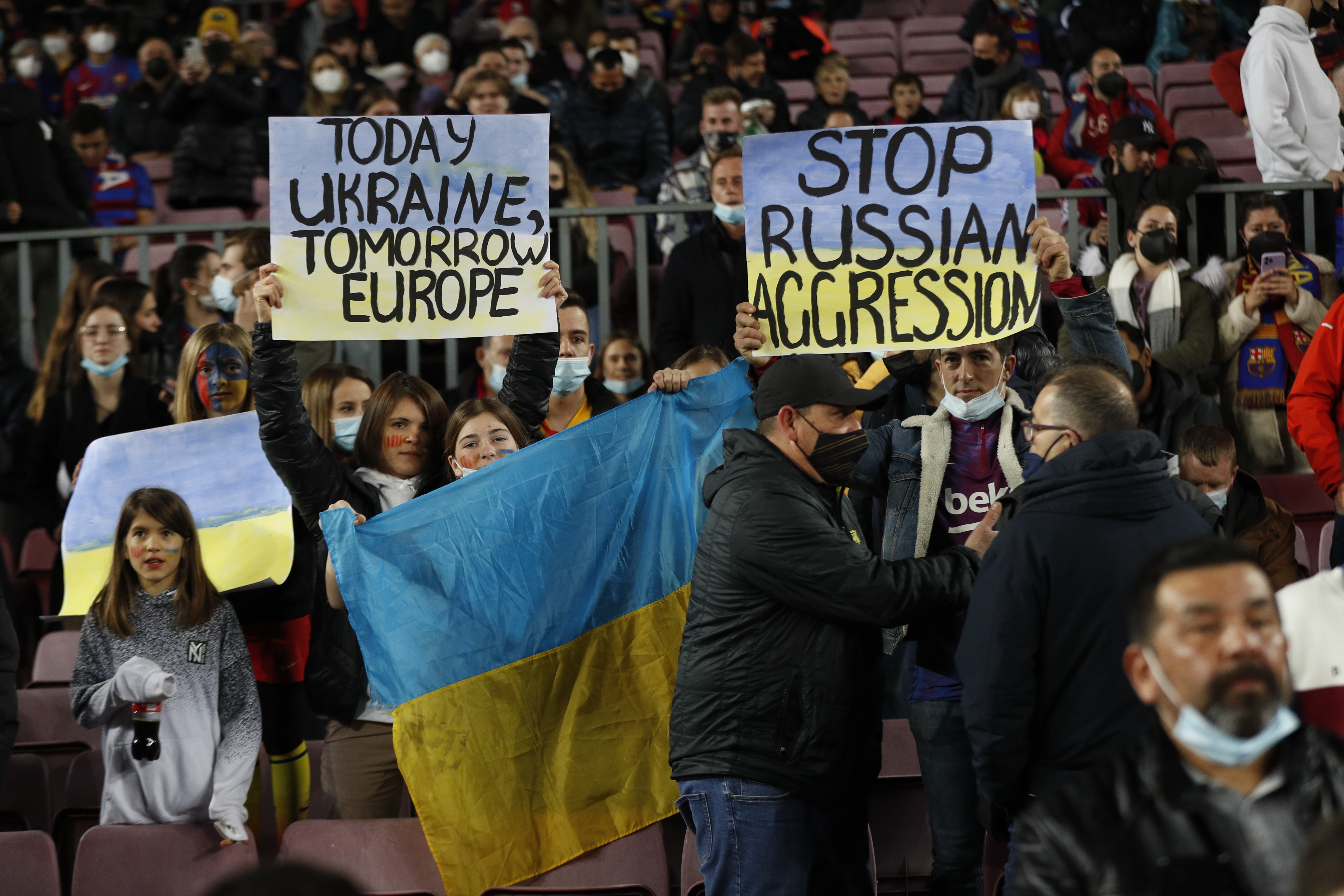 BARCELONA, 27/02/2022.- Asistentes al Camp Nou muestran carteles contra la invasión de Rusia a Ucrania, antes del inicio del encuentro correspondiente a la jornada 26 de primera división que disputan hoy domingo FC Barcelona y Athletic Club en el estadio blaugrana. EFE / Alejandro García.