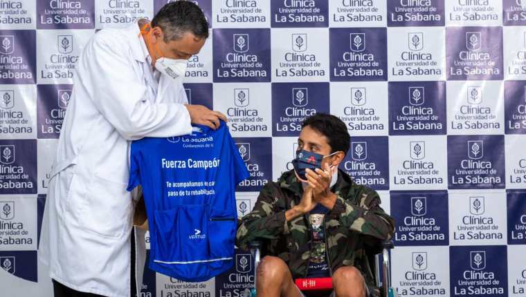 Esta imagen distribuida por la Clínica La Sabana muestra al colombiano Egan Bernal (der.), exganador del Tour de Francia, aplaudiendo junto al director de la Clínica, Juan Guillermo Ortiz (izq.), en Bogotá, el 6 de febrero de 2022.  (Foto Clínica La Sabana / AFP)