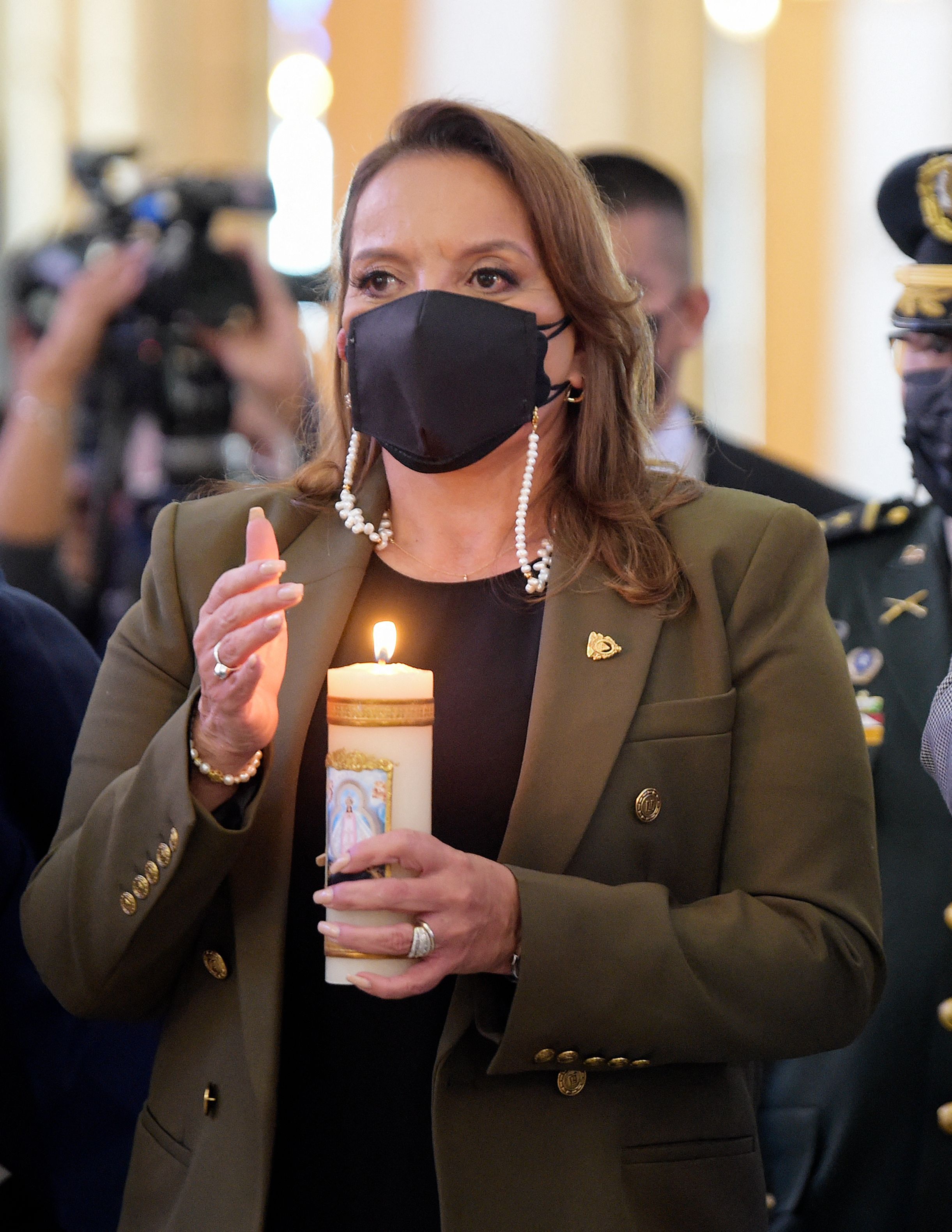 Honduran president-elect Xiomara Castro holds a candle during a mass organized by the Armed Forces on the 275th anniversary of the apparition of the Suyapa Virgin, Patron Saint of Honduras, in Tegucigalpa on February 1, 2022. (Photo by Orlando SIERRA / AFP)