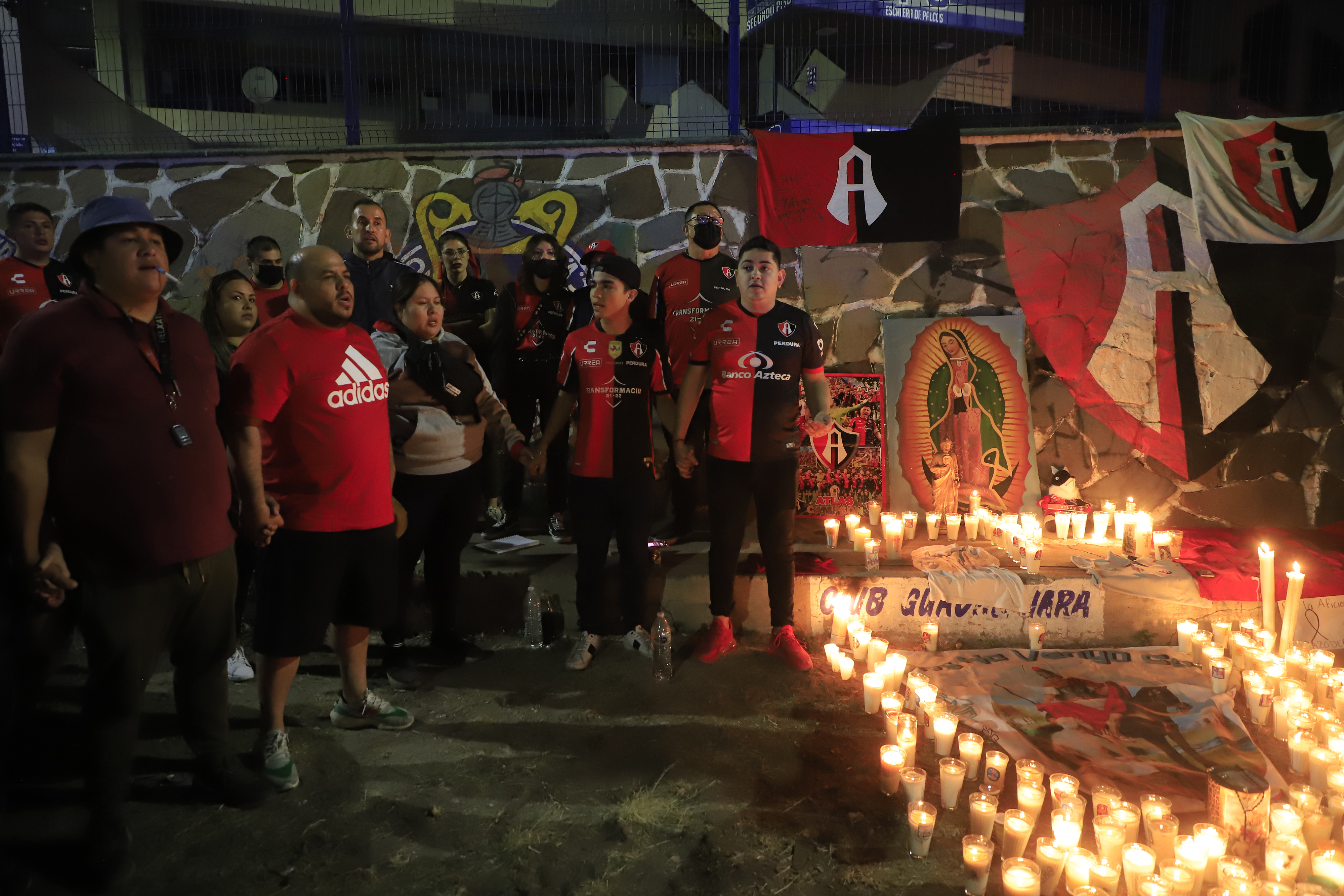 Aficionados del Club Atlas, encienden velas en la madrugada del  domingo, en las inmediaciones del estadio Jalisco, en la ciudad de Guadalajara. (Foto Prensa Libre: EFE)