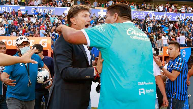 Un aficionado del Querétaro (D) confronta al director técnico de su equipo, el argentino Hernán Cristante (I) durante el juego ante el Atlas que terminó con un enfrentamiento violento entre los fanáticos. Foto Prensa Libre: AFP.