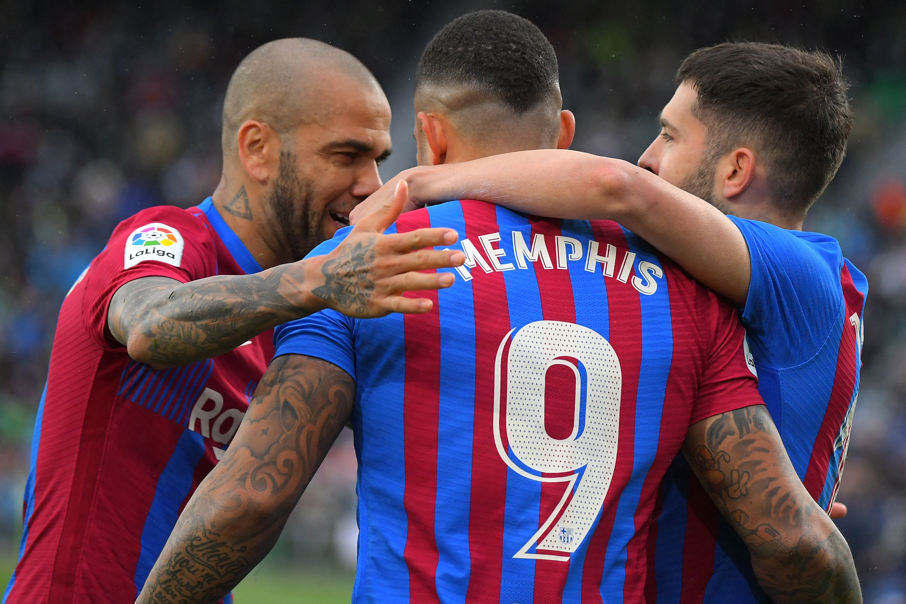 El jugador del Barcelona Memphis Depay festeja el segundo gol de los suyos con sus compañeros, Dani Alves y Jordi Alba.(Foto Prensa Libre: AFP)