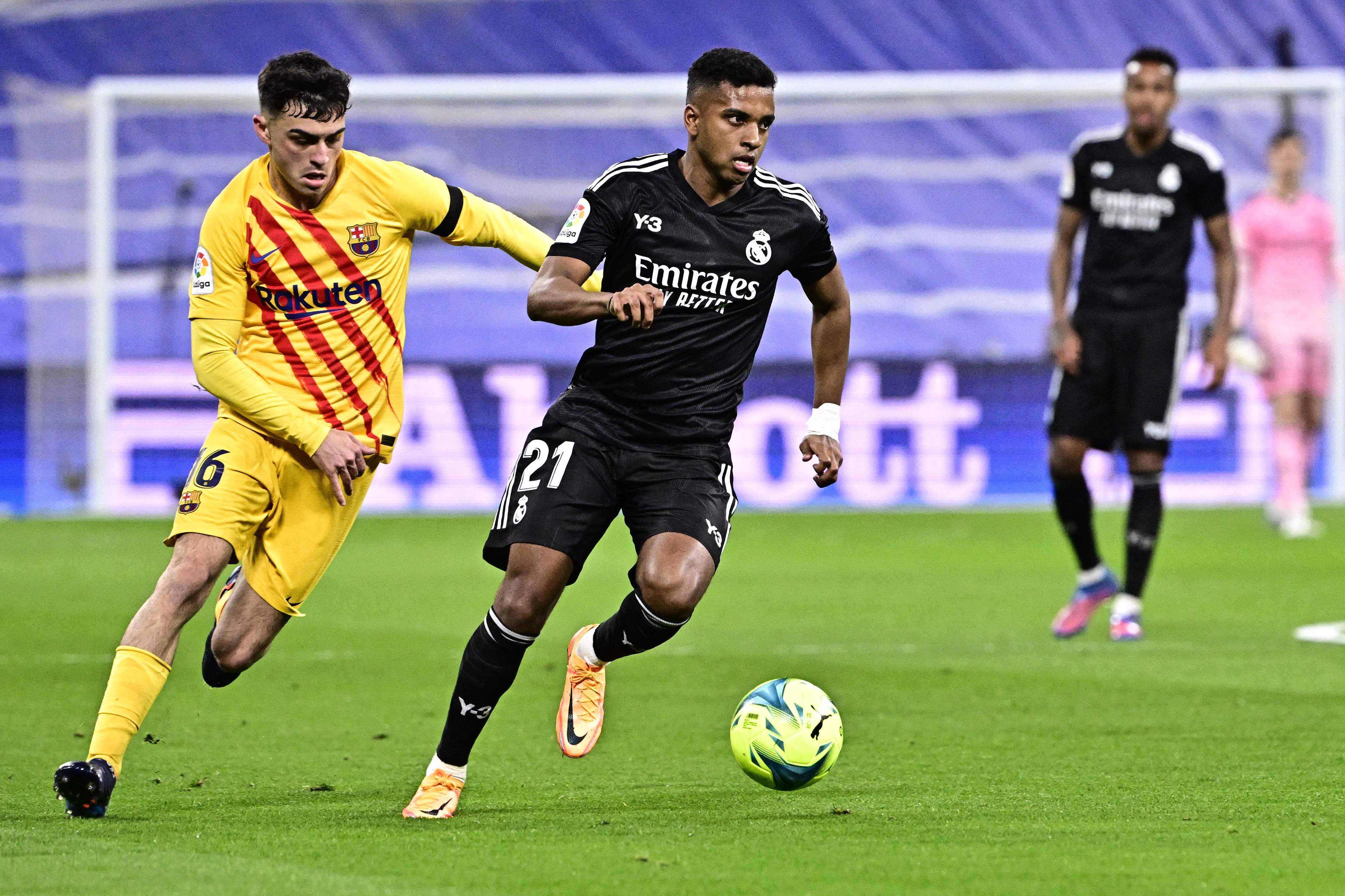 Real Madrid's Brazilian forward Rodrygo (R) vies with Barcelona's Spanish midfielder Pedri during the Spanish League football match between Real Madrid CF and FC Barcelona at the Santiago Bernabeu stadium in Madrid on March 20, 2022. (Photo by JAVIER SORIANO / AFP)