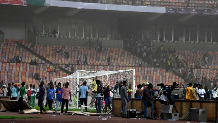 Angry football fans invade the pitch as violence broke-out following Ghana's defeat over Nigeria at the World Cup 2022 qualifying football match between Nigeria and Ghana at the National Stadium in Abuja on March 29, 2022. (Photo by PIUS UTOMI EKPEI / AFP)