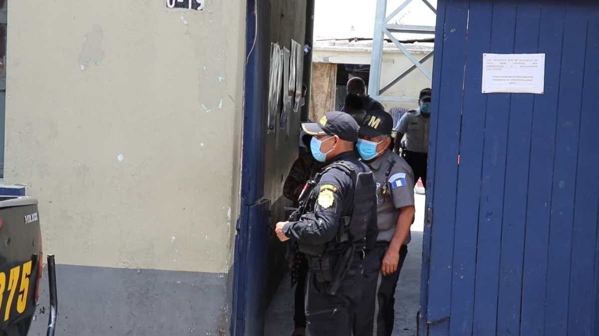 Un agente de la Policía Municipal de Santa Cruz del Quiché que es vinculado con una banda de secuestradores es resguardado por agentes de la PNC y algunos de sus compañeros. (Foto Prensa Libre: Héctor Cordero)
