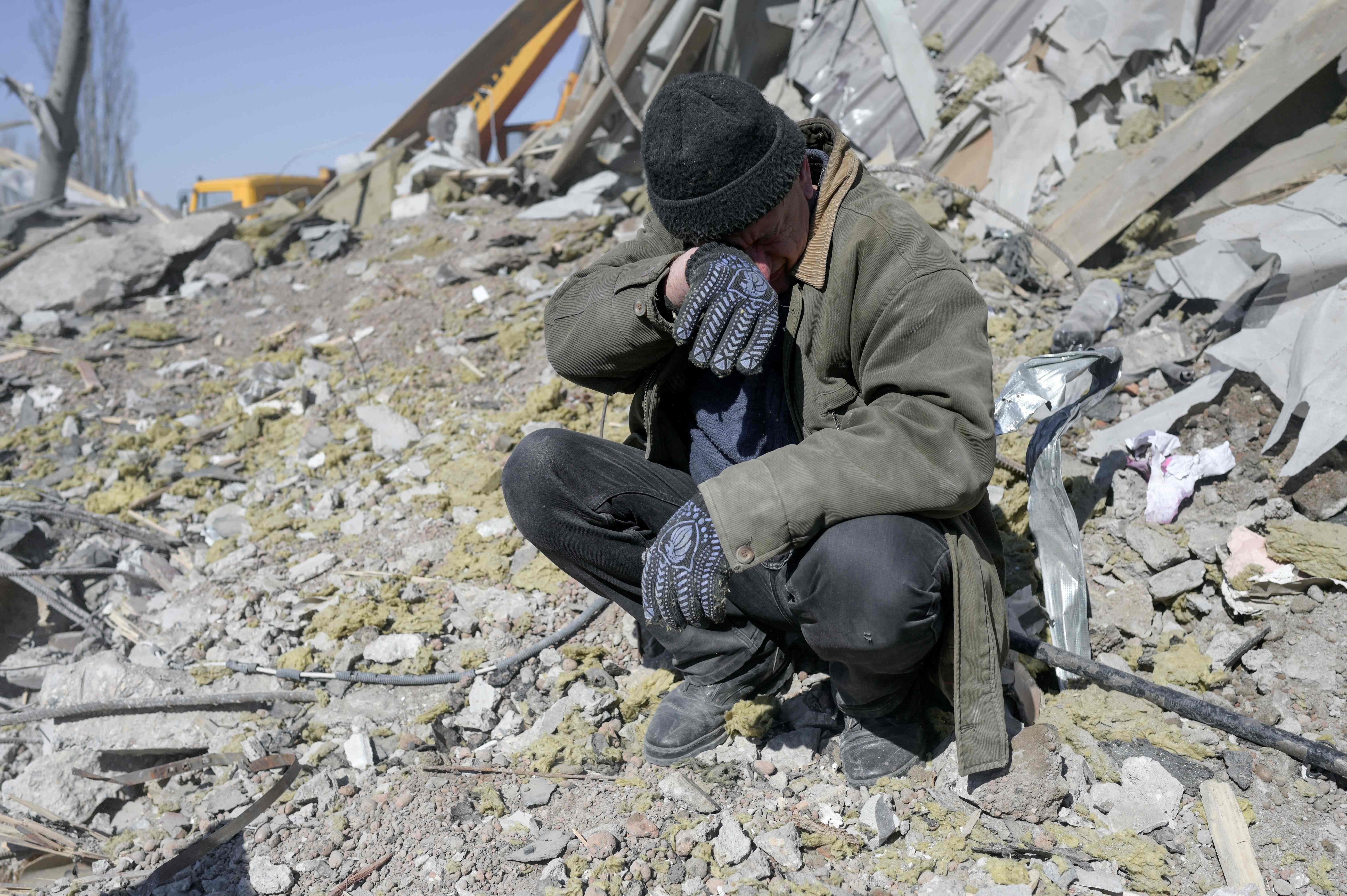 Un hombre ayuda a soldados ucranianos en la búsqueda de cuerpos entre los escombros de una escuela militar destruida en Mykolaiv, al sur de Ucrania. (Foto Prensa Libre: AFP)