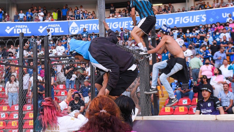 Aficionados del Querétaro y aficionados del Atlas originaron un conato de pelea que terminó invadiendo la cancha, durante un juego correspondiente a la jornada 9 del Torneo Clausura 2022 de la Liga MX del fútbol mexicano en el estadio Corregidora de la ciudad de Querétaro, México. (Foto Prensa Libre: EFE)