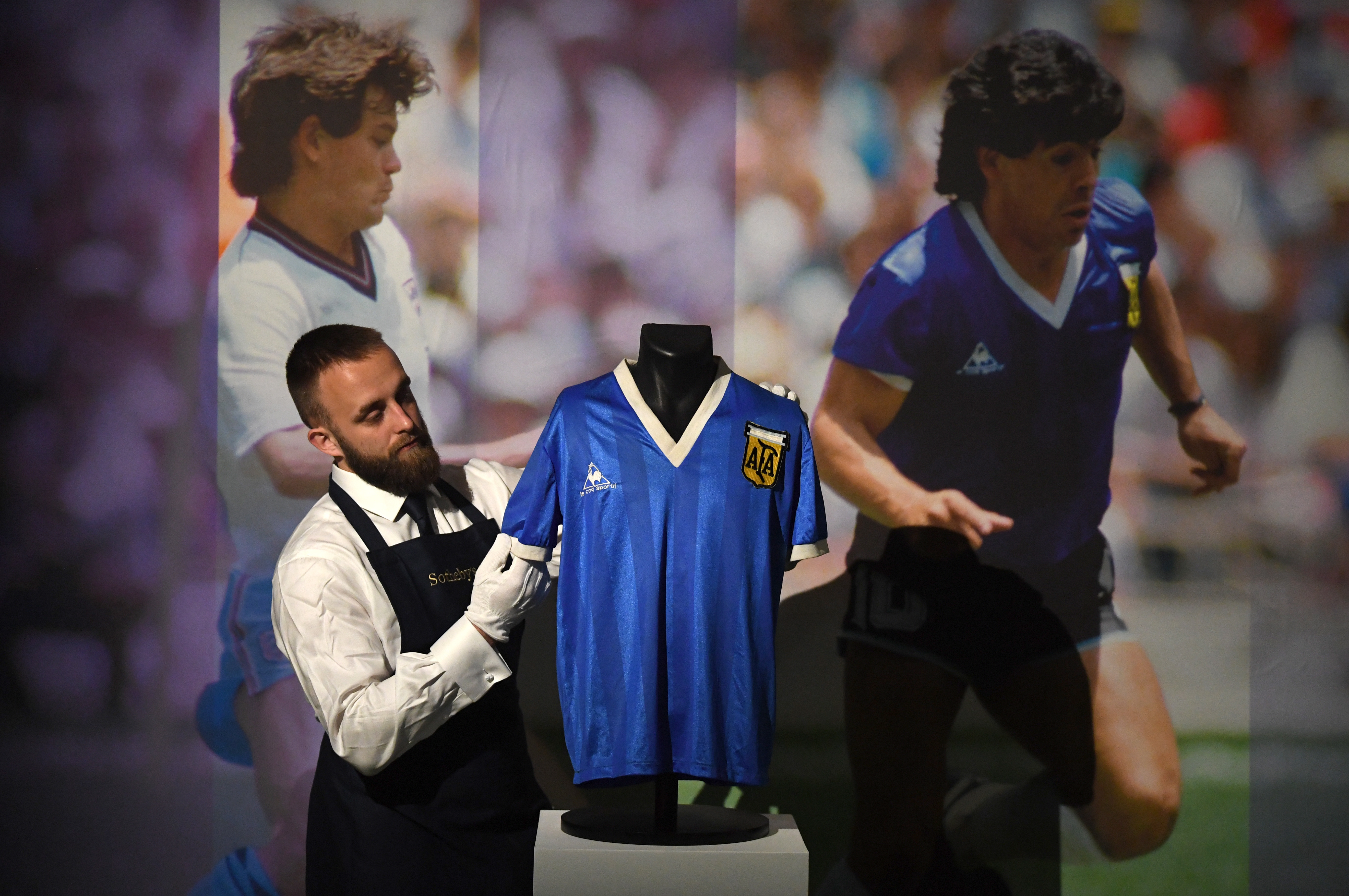 London (United Kingdom), 20/04/2022.- An auction house worker poses with Argentine footballer Diego Maradona's 1986 World Cup quarter final match shirt at Sotheby's Auction House in Britain, 20 April 2022. The shirt was worn by Maradona as he scored both the Hand of God and the Goal of the Century goals against the England Team. The online auction runs from 20 April to 04 May 2022 and the estimate is in excess of 4 Million Pounds Sterling. (Mundial de Fútbol, Reino Unido) EFE/EPA/NEIL HALL