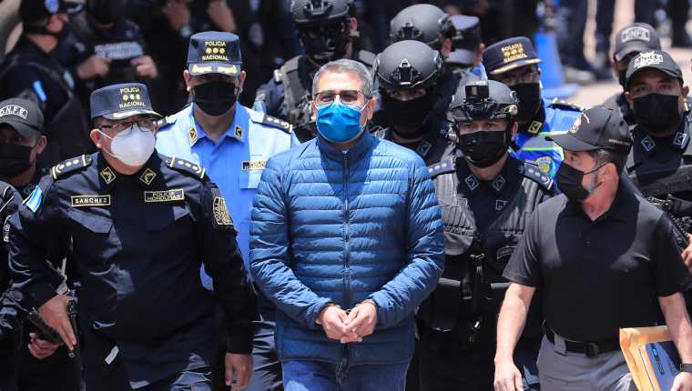 Policías custodian al expresidente hondureño Juan Orlando Hernández (c) rumbo a su extradición en la sede de la Dirección Nacional Fuerzas Especiales, en Tegucigalpa. (Foto Prensa Libre: EFE)
