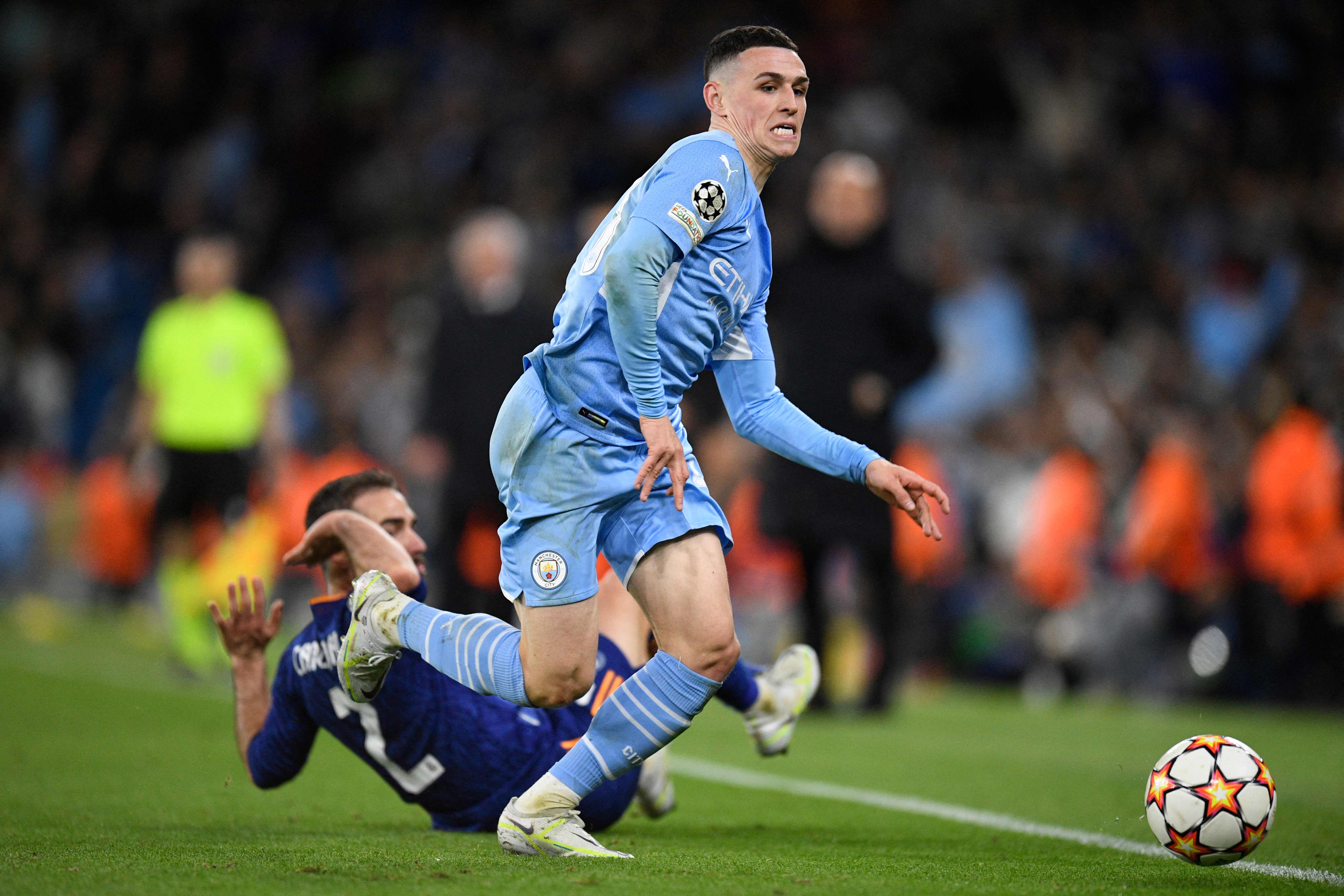 Manchester City's English midfielder Phil Foden runs with the ball during the UEFA Champions League semi-final first leg football match between Manchester City and Real Madrid, at the Etihad Stadium, in Manchester, on April 26, 2022. (Photo by Oli SCARFF / AFP)