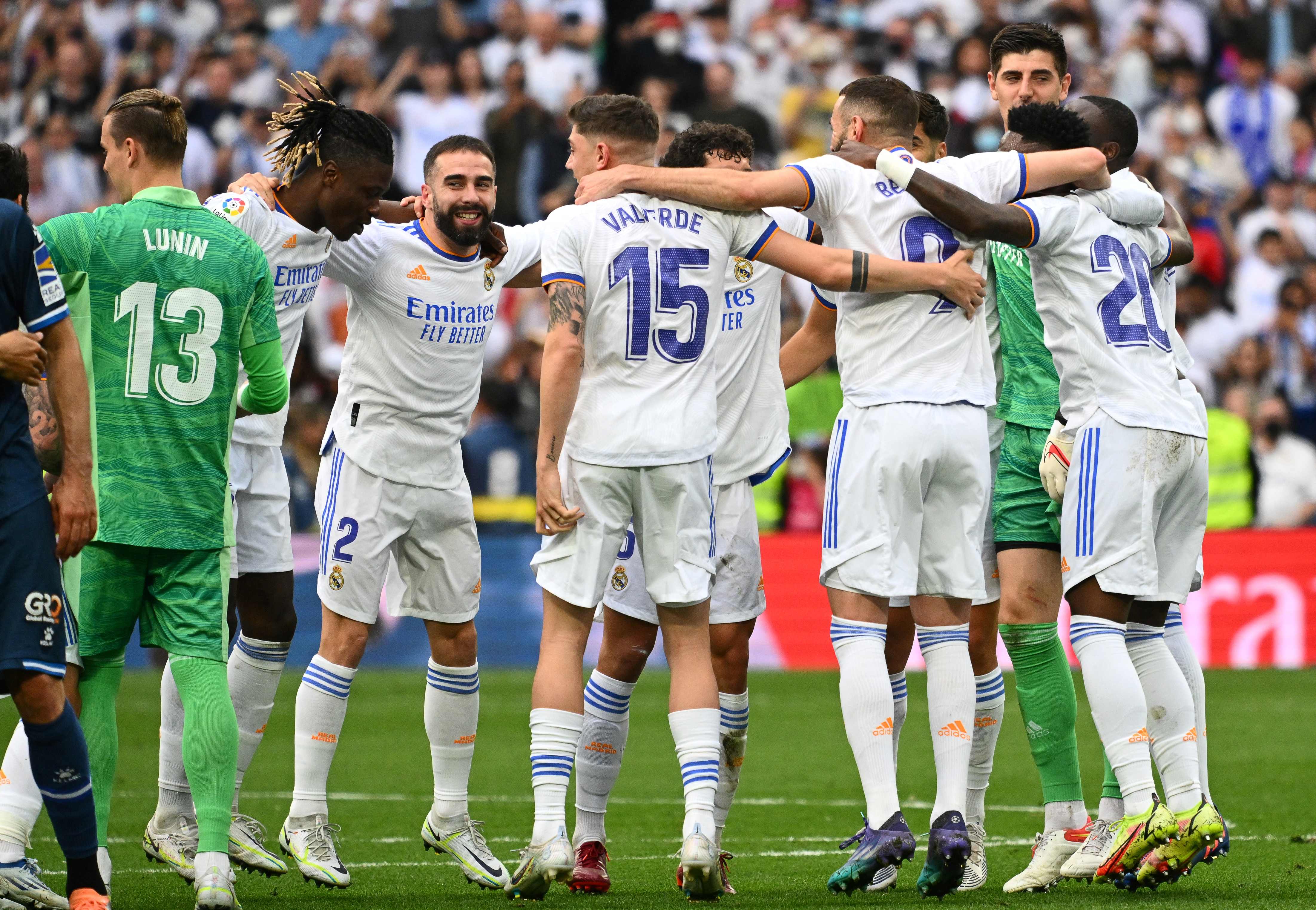 Real Madrid's players celebrate at the end of the Spanish League football match between Real Madrid CF and RCD Espanyol at the Santiago Bernabeu stadium in Madrid on April 30, 2022. - Real Madrid secured a 35th La Liga title with four games to spare after a 4-0 home win over Espanyol that included two goals from Rodrygo. Needing just one point to clinch the trophy, Madrid struck twice through the Brazilian in the first half at the Santiago Bernabeu before further goals from Marco Asensio and Karim Benzema. (Photo by GABRIEL BOUYS / AFP)