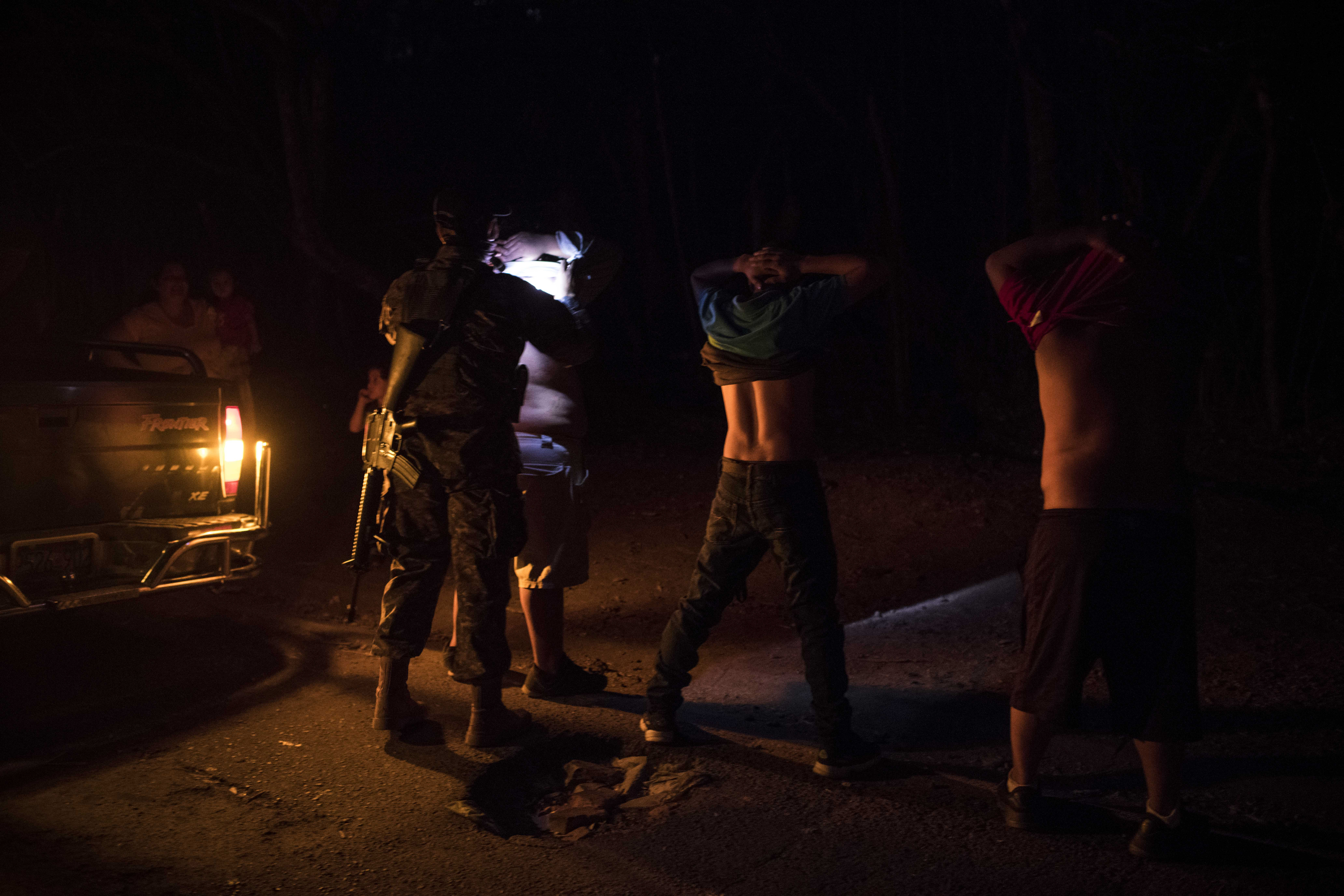 Soldados salvadoreños registrando a hombres en busca de tatuajes de pandillas este mes en Tonacatepeque. (Foto Prensa Libre: Daniele Volpe/The New York Times)