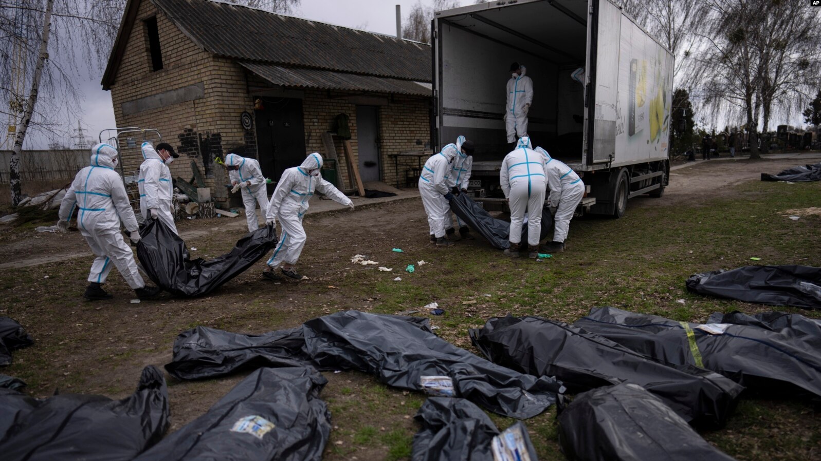 Voluntarios recogen cadáveres de civiles de civiles asesinados en Bucha, Ucrania, el 12 de abril de 2022. (Foto Prensa Libre: VOA)
