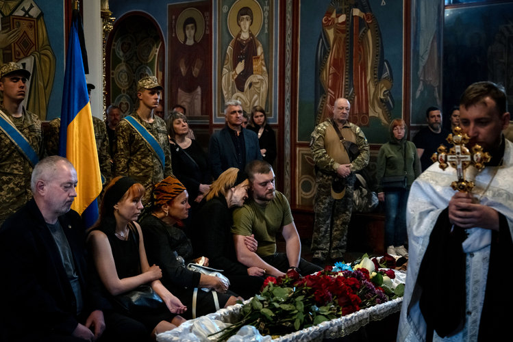 un grupo de familiares lloran durante el funeral del soldado ucraniano Eduard Trypilchenko, de 34 años, en la Capilla del Monasterio de San Miguel en Kyiv, Ucrania, el miércoles 25 de mayo de 2022. (Nicole Tung/The New York Times)