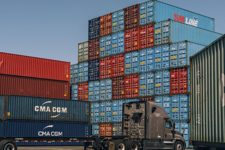 Contenedores apilados en muelles son ordenados y descargados en camiones en el Puerto de Los Ángeles en San Pedro, California, el 23 de marzo de 2022. (Coley Brown/The New York Times)