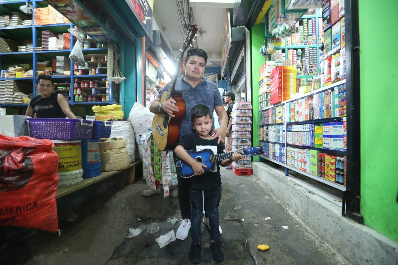 Eduardo Martínes Sandoval, de 23 años y su hijo Eduardo Gabriel, de 7, son mexicanos y y recorren los pasillos del mercado “La Terminal”, zona 4 para recaudar fondos y volver a casa. Foto Prensa Libre: Roberto López. 