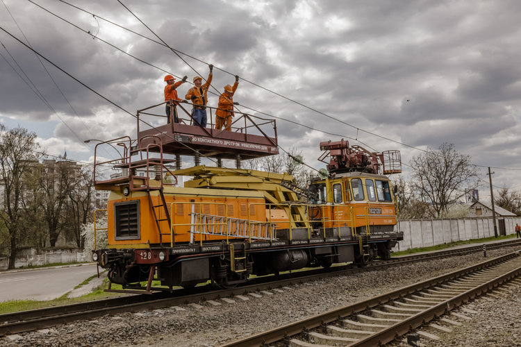 Un grupo de trabajadores reparan la infraestructura eléctrica dañada a lo largo de una vía férrea en Bucha, Ucrania, el domingo 1 de mayo de 2022. (Daniel Berehulak/The New York Times)