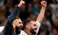 Real Madrid's French forward Karim Benzema and Real Madrid's Spanish defender Dani Carvajal (R) celebrate after the UEFA Champions League semi-final second leg football match between Real Madrid CF and Manchester City at the Santiago Bernabeu stadium in Madrid on May 4, 2022. (Photo by GABRIEL BOUYS / AFP)