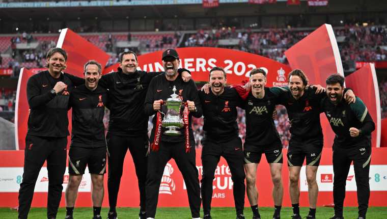 Jurgen Klopp  celebra con miembros de equipo de Liverpool, después de haber ganado la FA Cup, después de vencer en la final al Chelsea. (Foto Prensa Libre: AFP).
