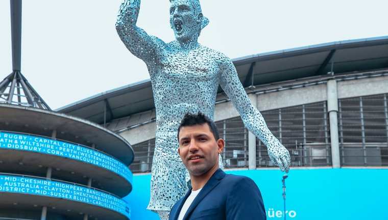 Sergio Agüero posa junto a su estatua que está en una las entradas del Etihad Stadium. (Foto Prensa Libre: Manchester City)