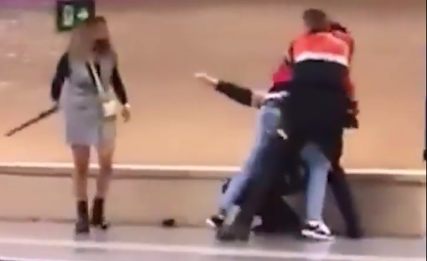 Foto de mujer golpeando agentes