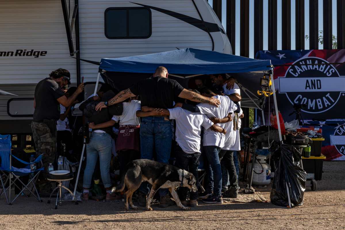 Seguidores de QAnon rezan con niños migrantes de Guatemala en el campamento de su grupo en Sasabe, Arizona, el 2 de mayo de 2022. (Foto Prensa Libre: Adriana Zehbrauskas/The New York Times)