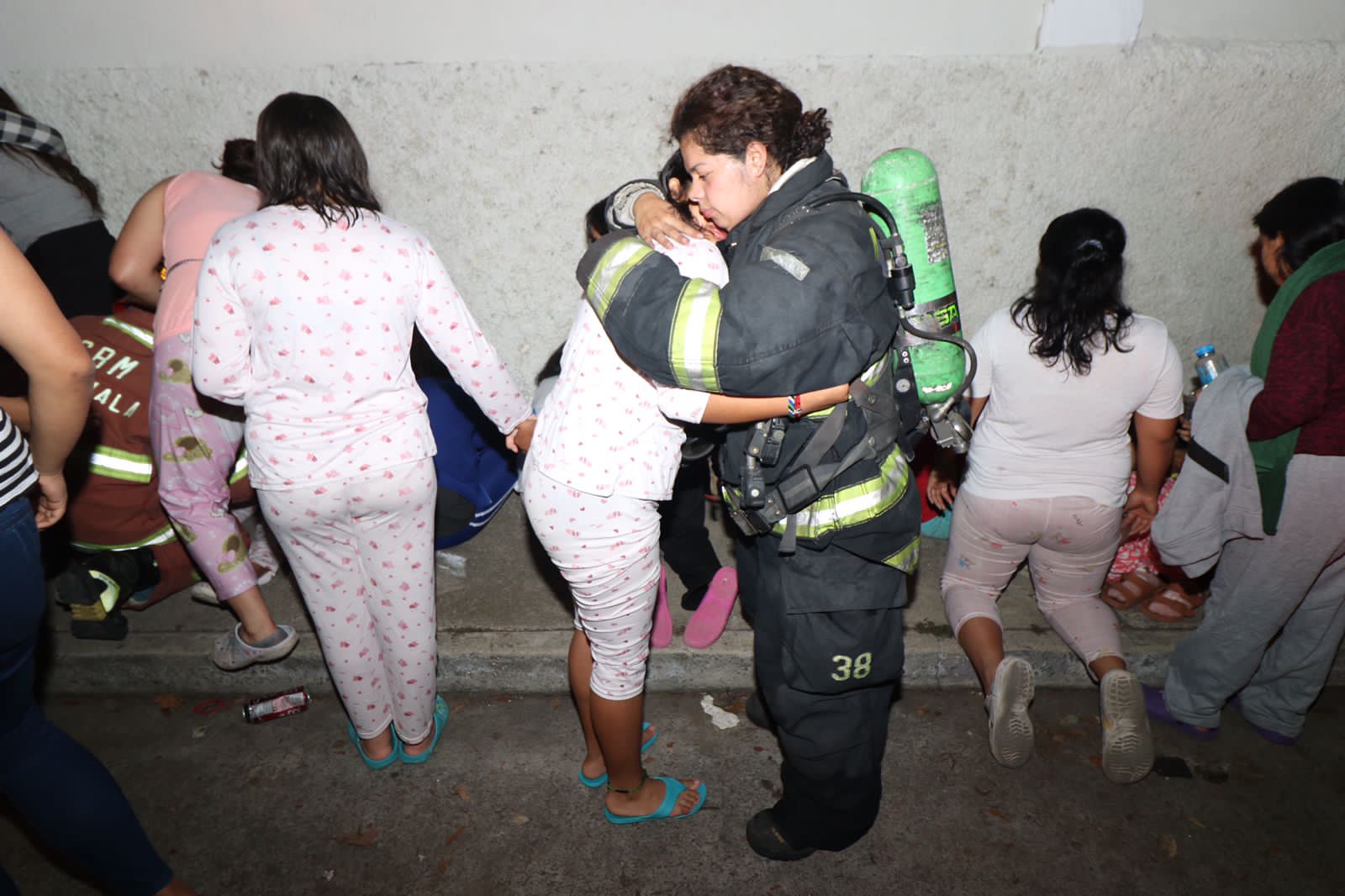 Una bombera voluntaria consuela a una de las 40 niñas que están albergadas en una casa hogar a cargo de la Secretaría de Bienestar Social de la Presidencia. Foto Bomberos Voluntarios. 