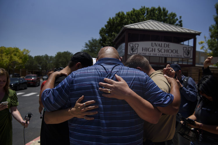 Residentes rezan junto a un policía estatal de Texas en la entrada de la primaria Robb en
Uvalde, Texas, el miércoles 25 de mayo de 2022. (Ivan Pierre Aguirre/The New York Times)