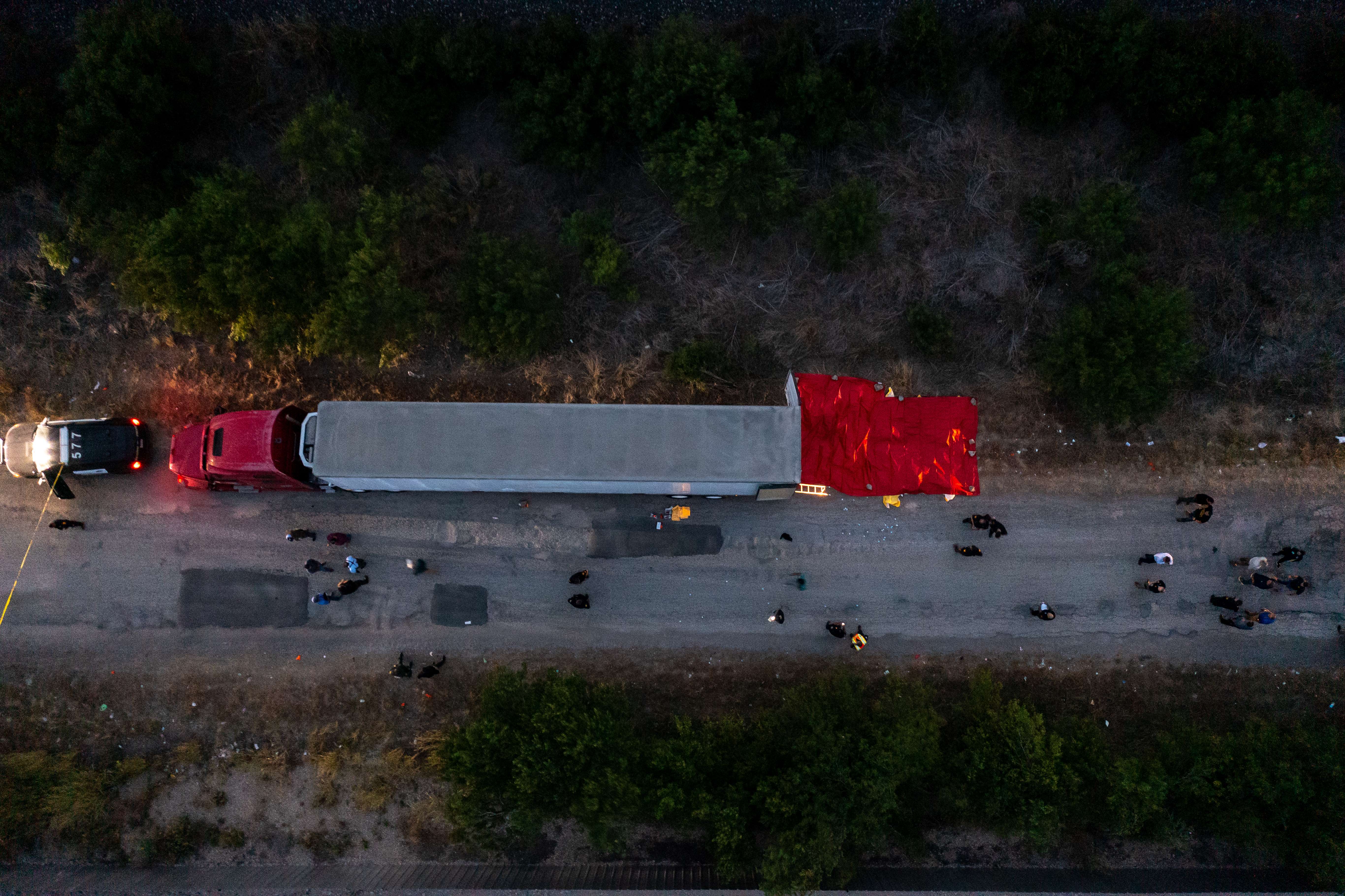 SAN ANTONIO, TX - JUNE 27: In this aerial view, members of law enforcement investigate a tractor trailer on June 27, 2022 in San Antonio, Texas. According to reports, at least 46 people, who are believed migrant workers from Mexico, were found dead in an abandoned tractor trailer. Over a dozen victims were found alive, suffering from heat stroke and taken to local hospitals. Jordan Vonderhaar/Getty Images/AFP == FOR NEWSPAPERS, INTERNET, TELCOS & TELEVISION USE ONLY ==