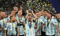 Argentina's striker Lionel Messi lifts the trophy as Argentina's players celebrate on the pitch after their victory in the 'Finalissima' International friendly football match between Italy and Argentina at Wembley Stadium in London on June 1, 2022. - The Azzurri face the South American continental champions in the inaugural Finalissima at Wembley. (Photo by Glyn KIRK / AFP)