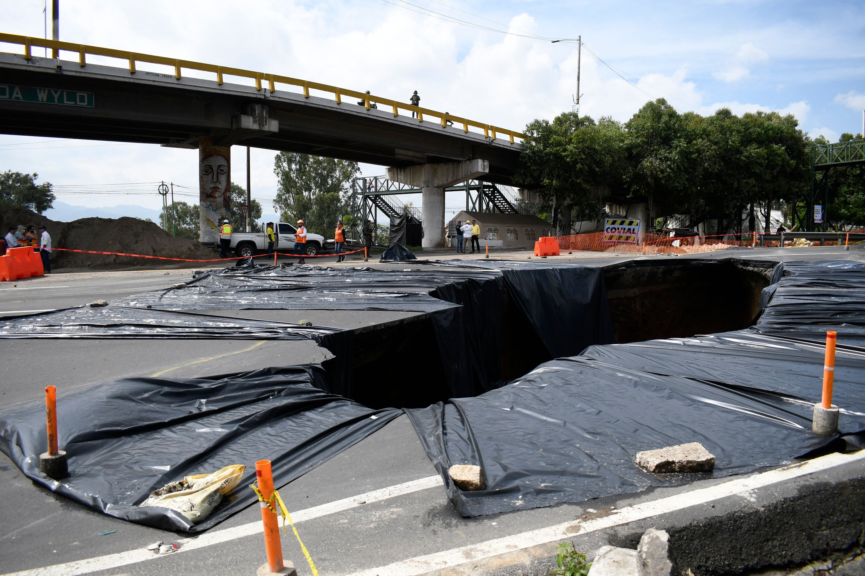 Vista del enorme agujero que se abrió en el kilómetro 15 de la ruta al Pacífico y que con los días crece más. (Foto Prensa Libre: AFP)