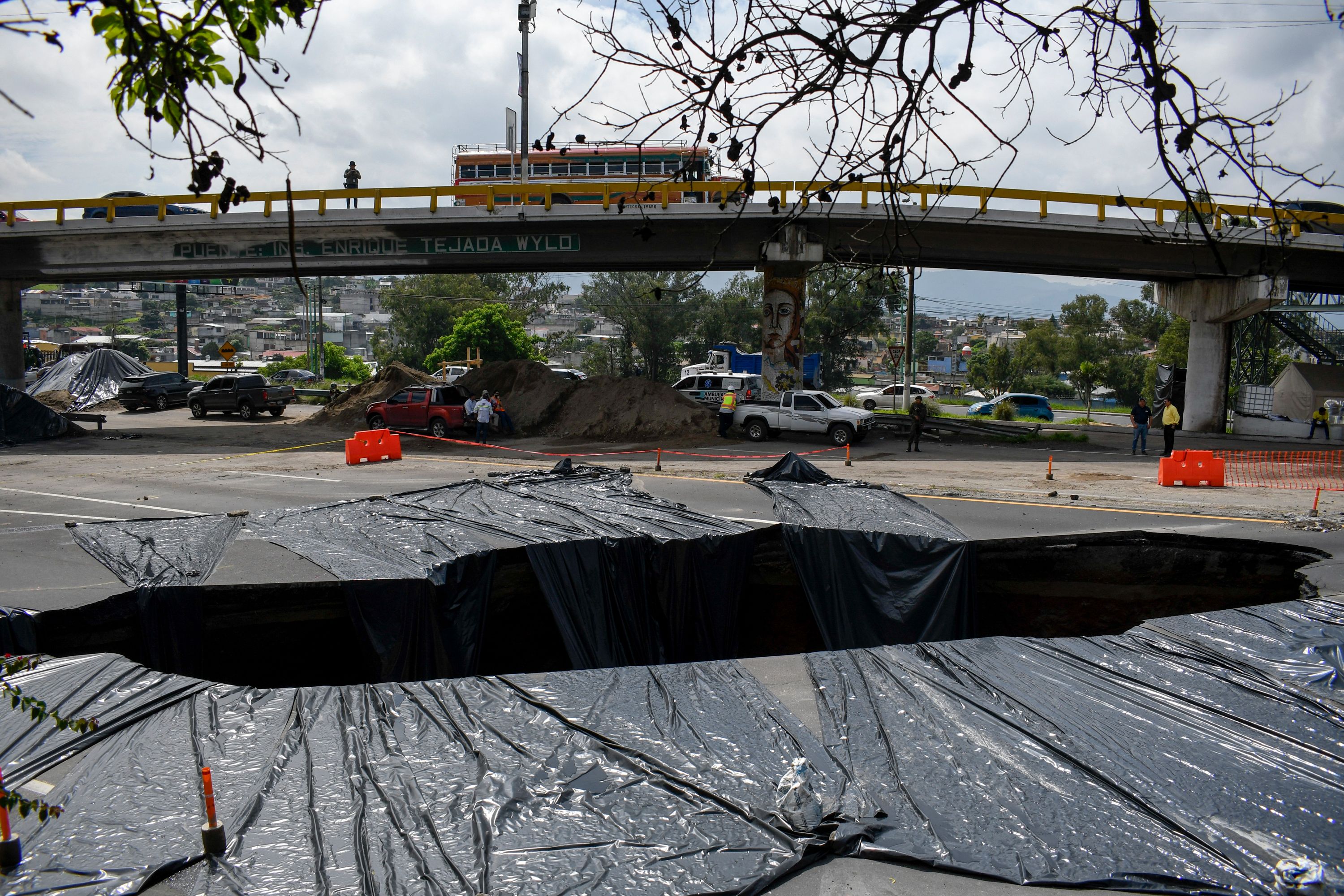 Vista del enorme agujero que se formó en el km 15 de la ruta al Pacífico a consecuencia de las fuertes lluvias. (Foto Prensa Libre: AFP)