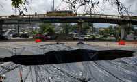 Vista del enorme agujero que se formó en el km 15 de la ruta al Pacífico a consecuencia de las fuertes lluvias. (Foto Prensa Libre: AFP)