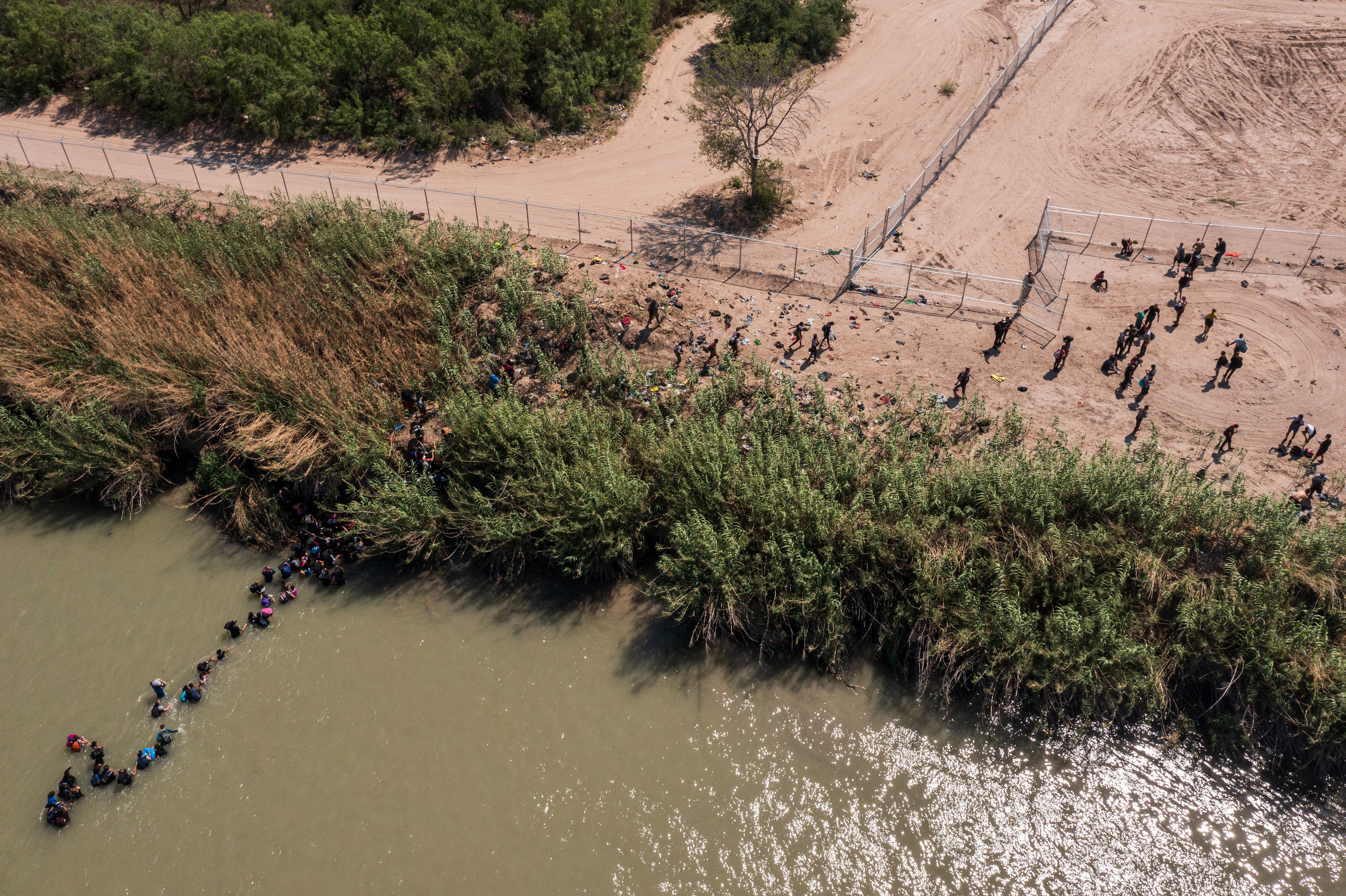 Un grupo de migrantes cruza el Río Grande cerca de Eagle Pass, Texas, el 16 de mayo de 2022. (Foto Prensa Libre: Tamir Kalifa/The New York Times)
