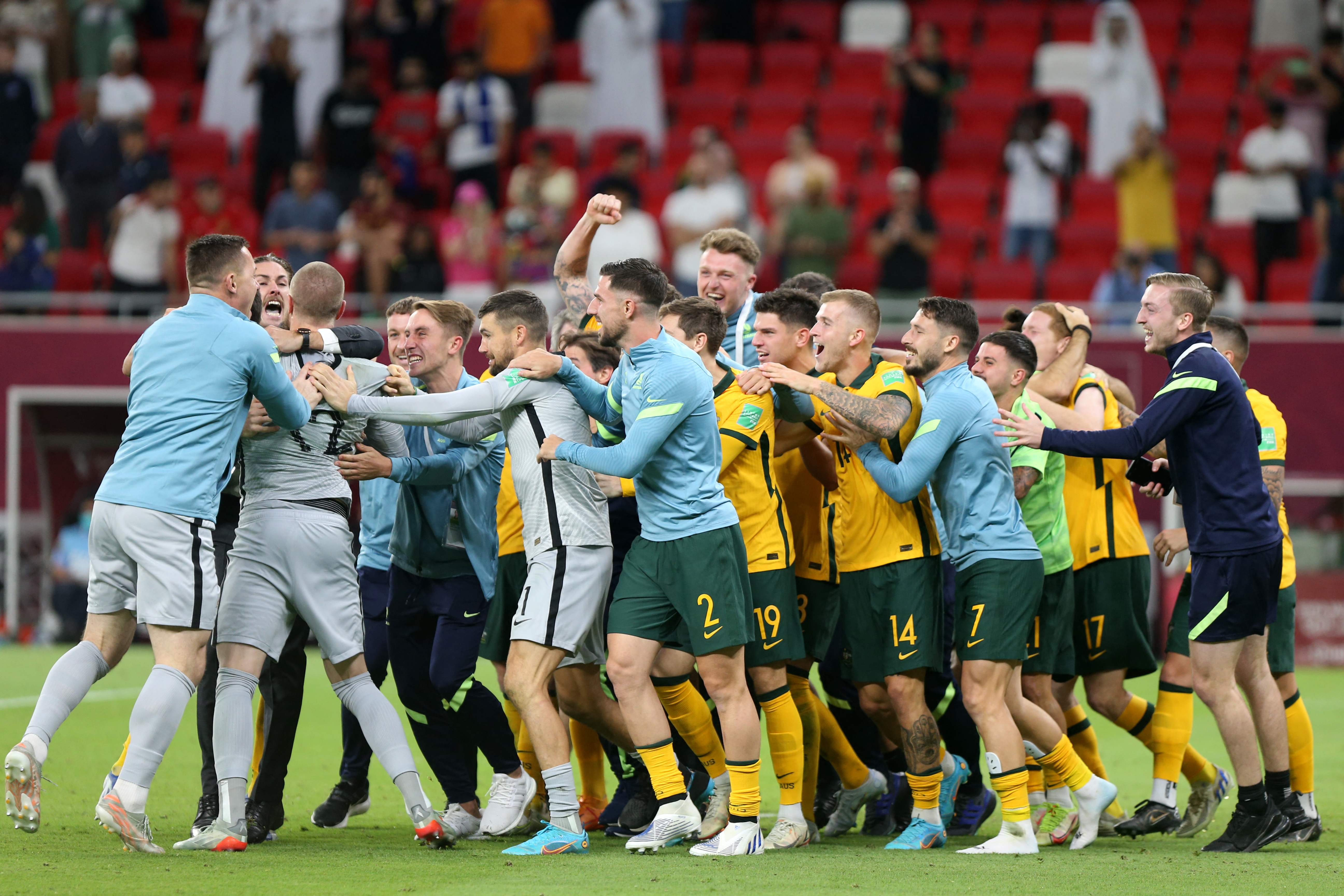Australia's players celebrate winning the FIFA World Cup 2022 inter-confederation play-offs match between Australia and Peru on June 13, 2022, at the Ahmed bin Ali Stadium in the Qatari city of Ar-Rayyan. (Photo by Mustafa ABUMUNES / AFP)