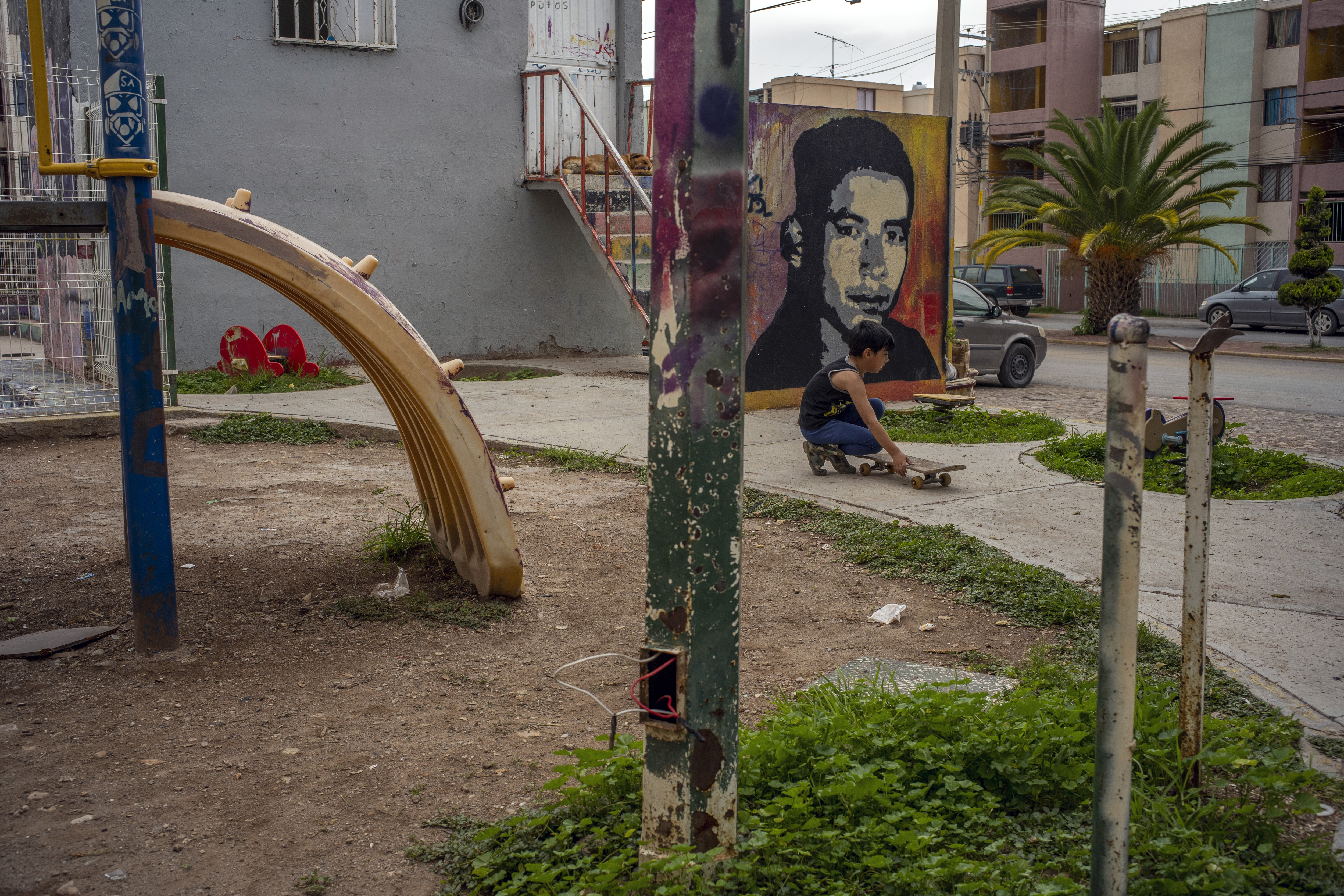 Un niño juega el 21 de julio del 2021 frente a un mural que representa a un joven asesinado, en el barrio de Olivares de Fresnillo, México. (Foto Prensa Libre: Alejandro Cegarra / The New York Times)