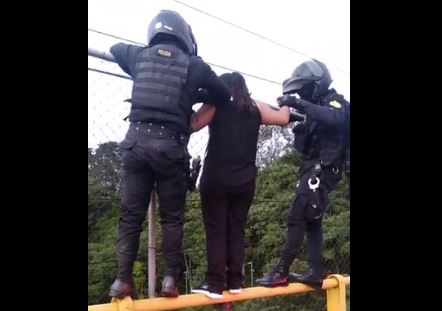Agentes convencen a mujer para que se baje de la estructura. (Foto: PNC)