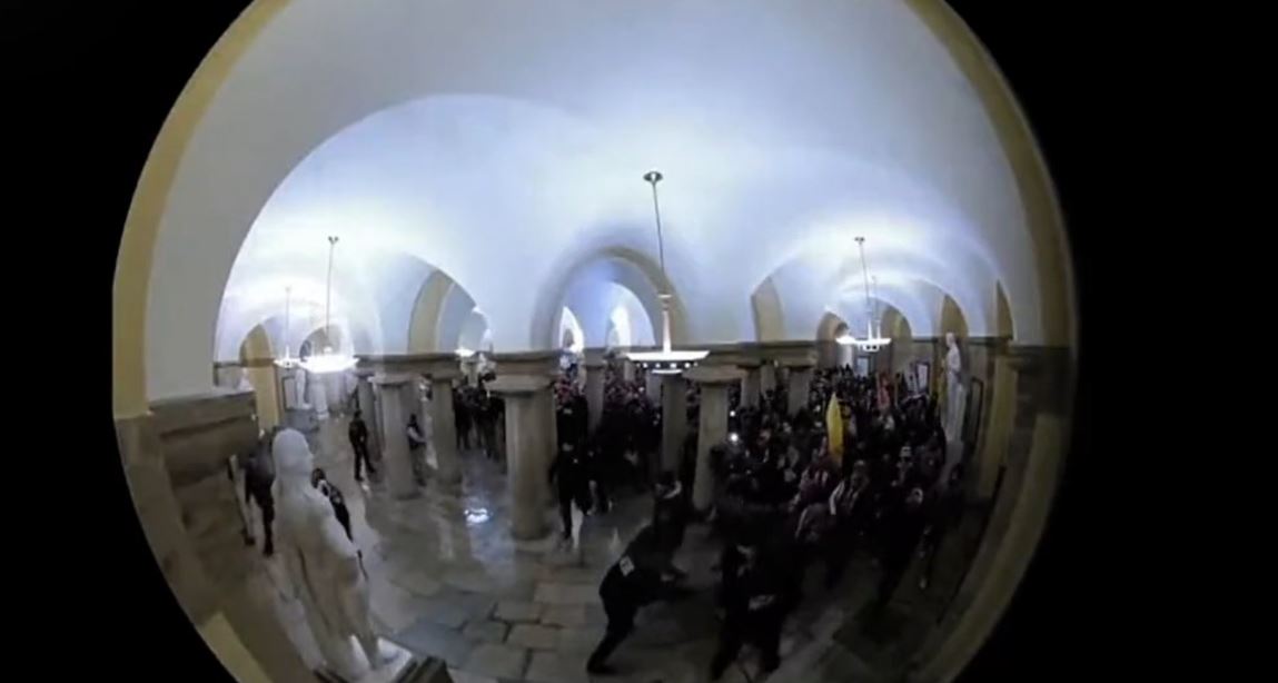 Momento en que la turba ingresa al Capitolio y se enfrenta a los guardias. (Imagen presentada durante la primera audiencia por la toma del Capitolio de EE. UU.)