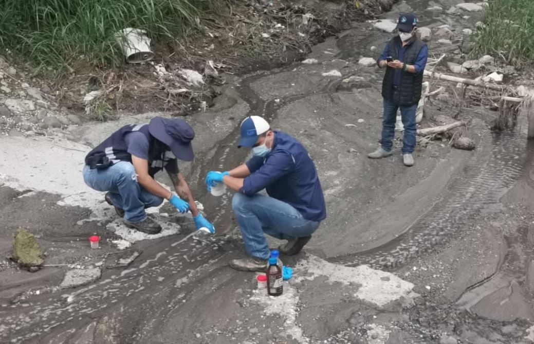Personal de la Municipalidad de Mixco y de Amsa toman muestras en el río de San Cristóbal para tratar de identificar la fuente de olores a químico que hay en el área. (Foto Prensa Libre: Facebook de Neto Bran)