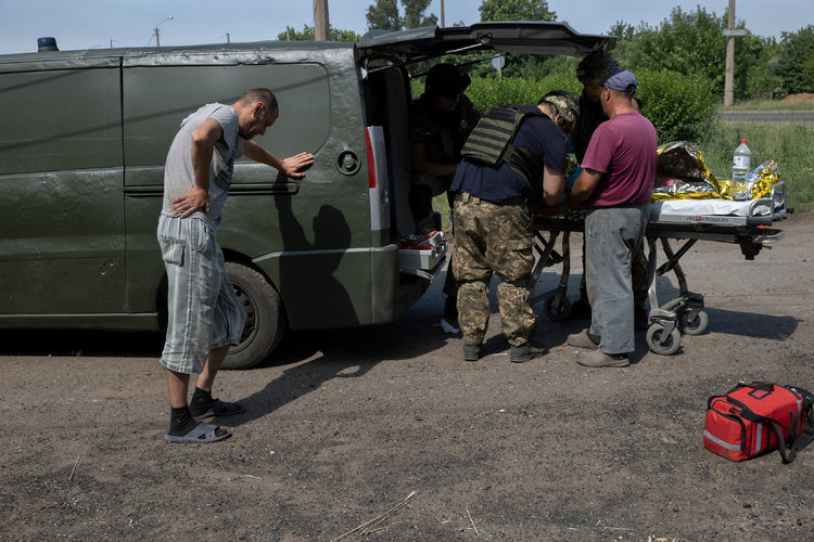 Médicos del ejército ucraniano atienden a Zina, en el centro, cerca de la ciudad de Bakhmut en la región oriental ucraniana de Donetsk, 29 de junio de 2022. (Foto Prensa Libre: Tyler Hicks/The New York Times)