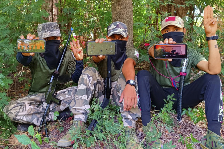 Miembros de la Fuerza de Defensa del Pueblo en Birmania muestran “War of Heroes”, el videojuego en línea, en sus teléfonos celulares.