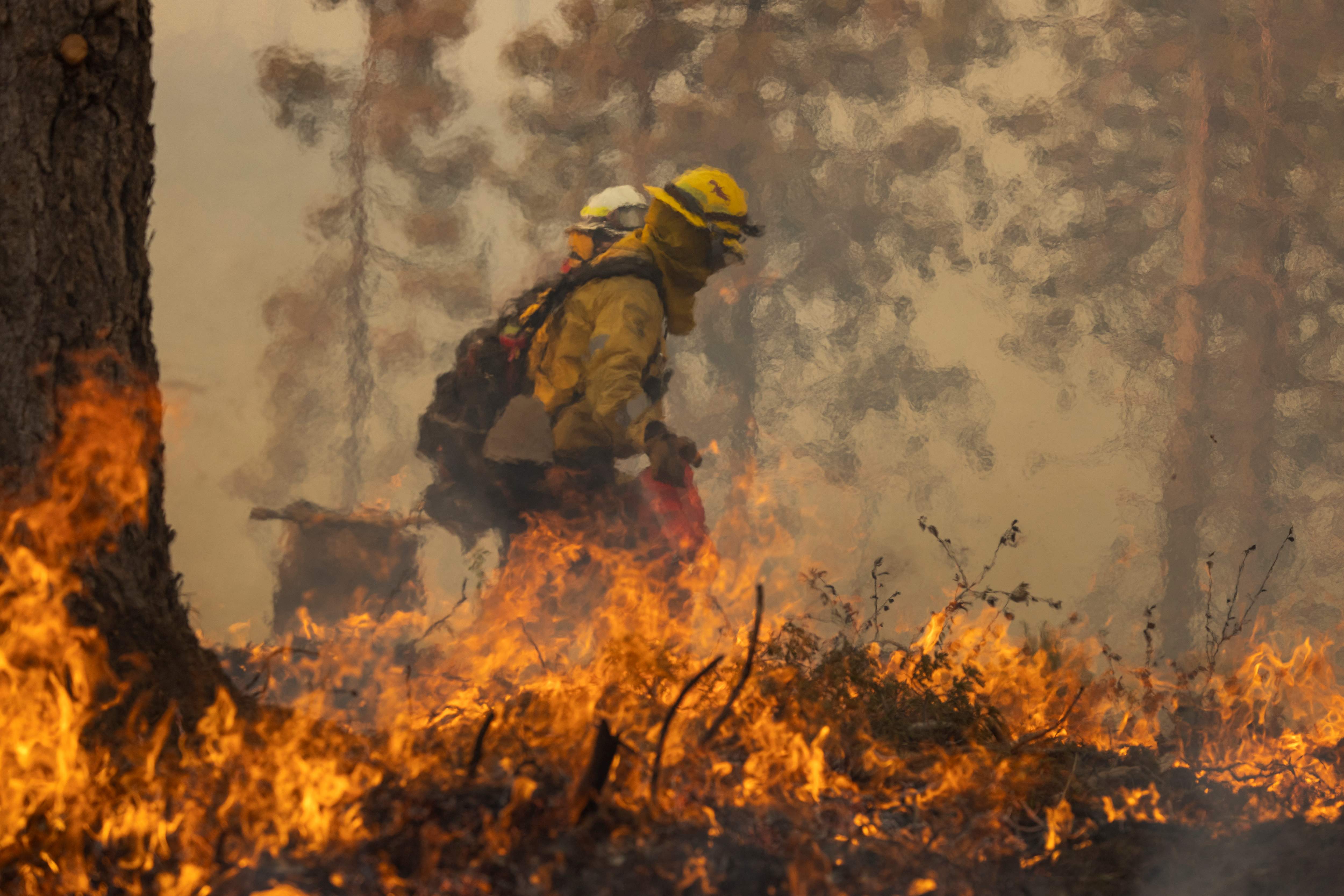 Foto de un un bombero durante un incendio forestal en Oak, California