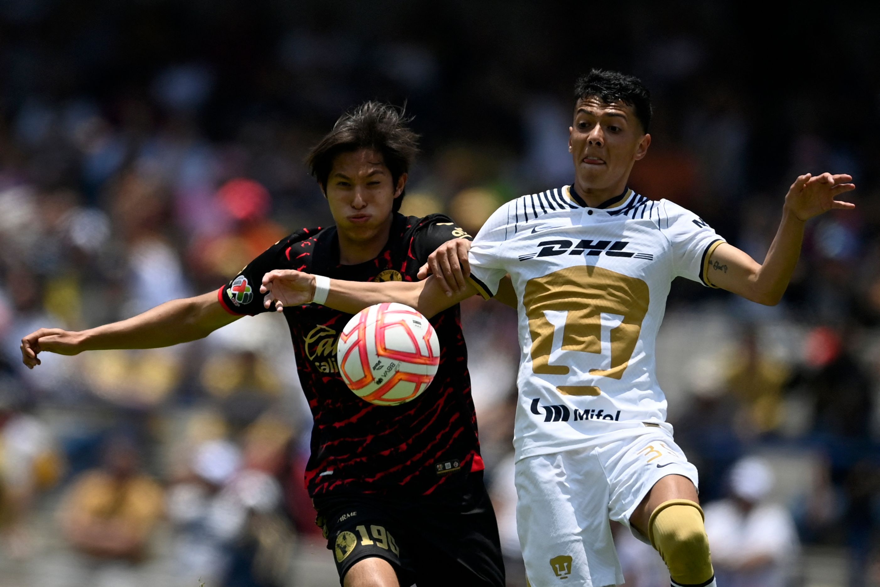 Pumas' midfielder Jorge Ruvalcaba (R) vies for the ball with Tiuana's defender Rodrigo Parra during their Mexican Apertura 2022 tournament football match at the University Olympic stadium in Mexico City, on July 3, 2022. (Photo by PEDRO PARDO / AFP)