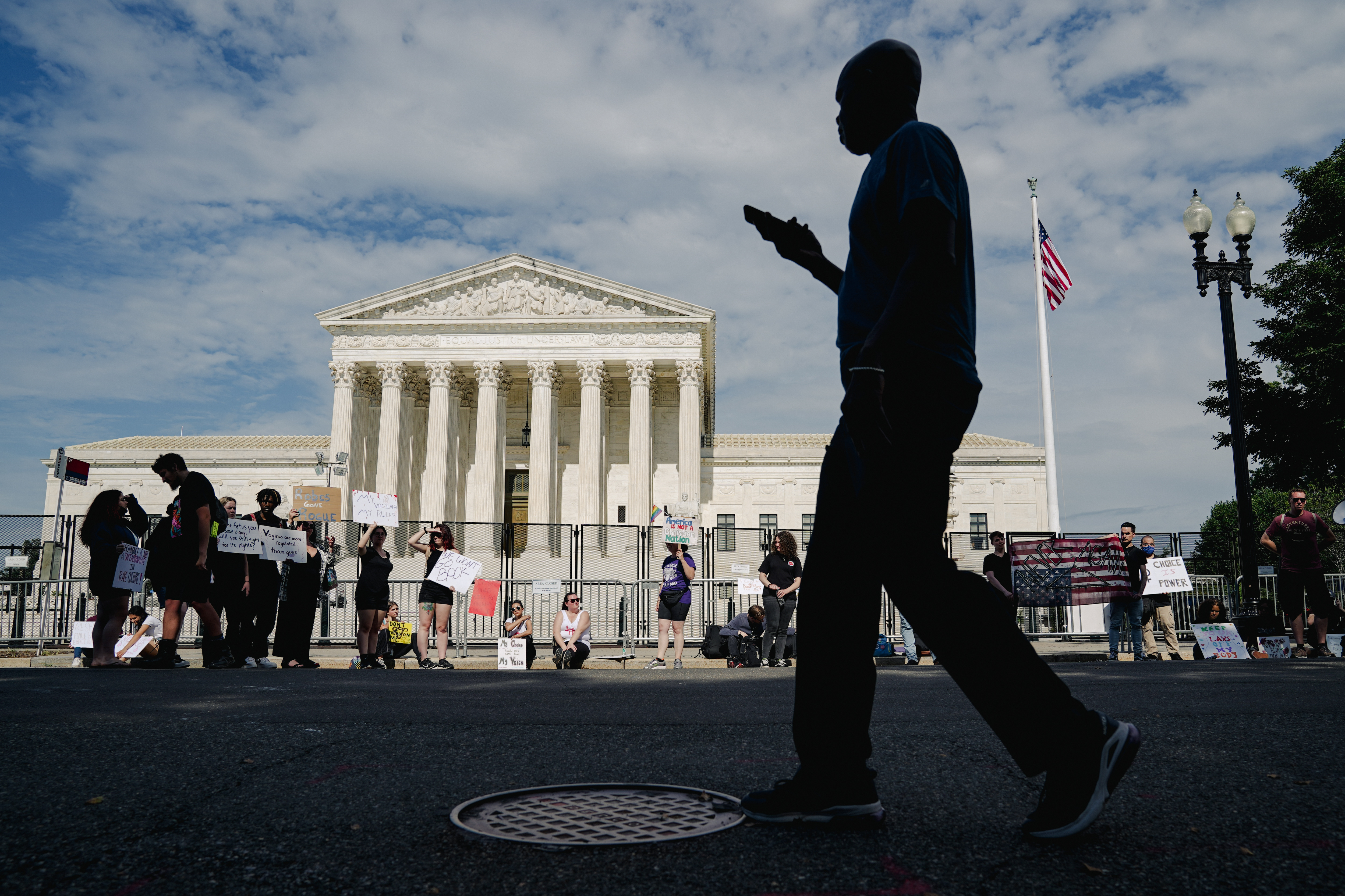 Una persona pasa junto a los partidarios del derecho al aborto mientras protestan ante el Tribunal Supremo en Washington el lunes 27 de junio de 2022. (Foto Prensa Libre: Shuran Huang/The New York Times)