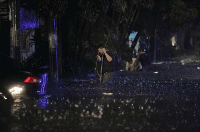 El diario salvadoreño La Prensa Gráfica reportó que pobladores de la colonia Luz en Monserrat destapan tragantes para evitar que la inundación llegue a sus hogares. Foto La Prensa Gráfica. 