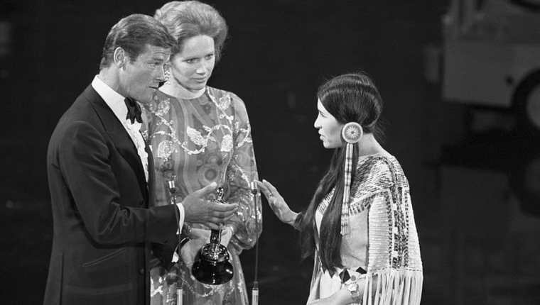 Los actores Roger Moore (izquierda) y Liv Ullman (centro) hacían entrega del premio que fue a recoger Sacheen Littlefeather (derecha), vestida con el traje Apache.
GETTY IMAGES
