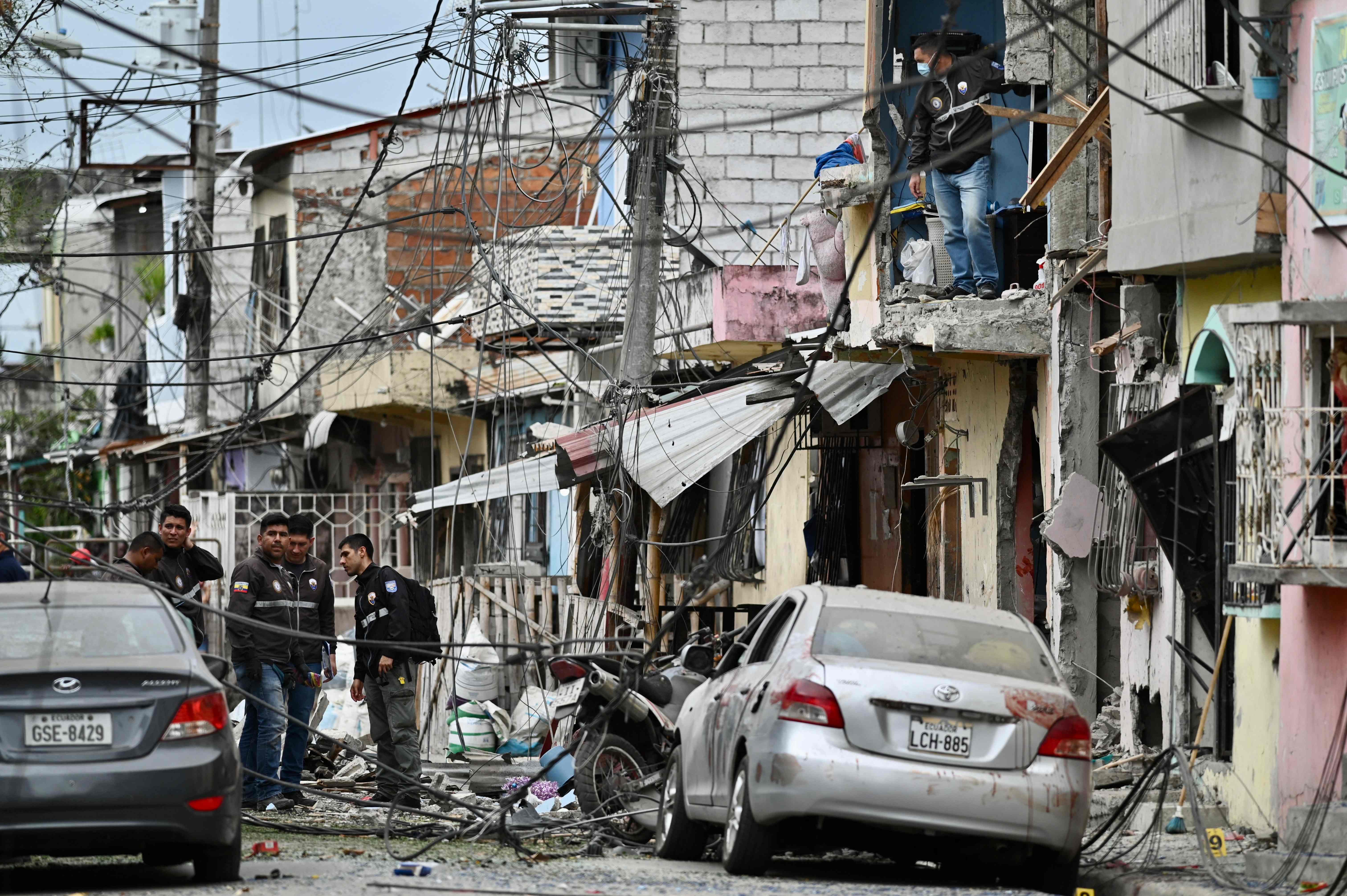La policía de Ecuador inspecciona el lugar donde ocurrió la explosión que mató a cinco personas y que se atribuye al crimen organizado. (Foto Prensa Libre: AFP)